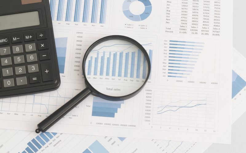 business-graphs-charts-magnifying-glass-and-calculator-on-table-financial-development.jpg